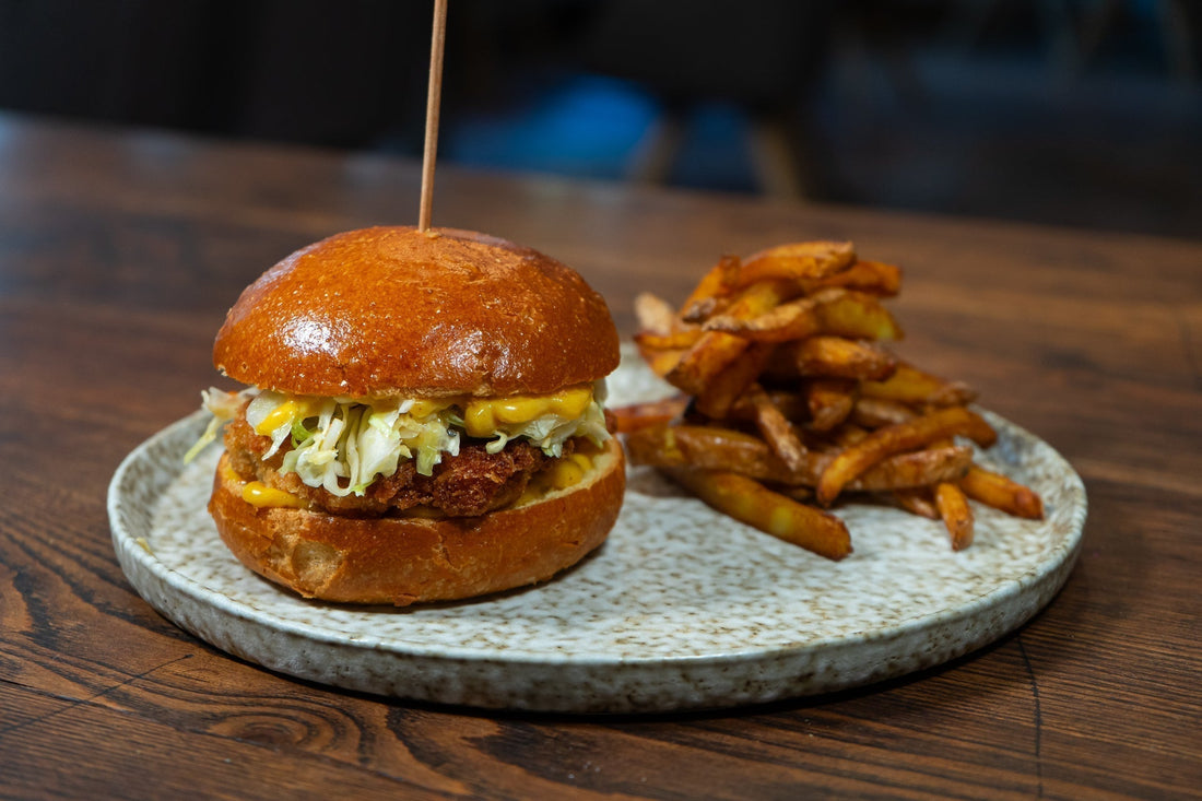 Crispy Chicken Burger mit asiatischem Spitzkrautsalat, Mango-Currymayo und Pommes