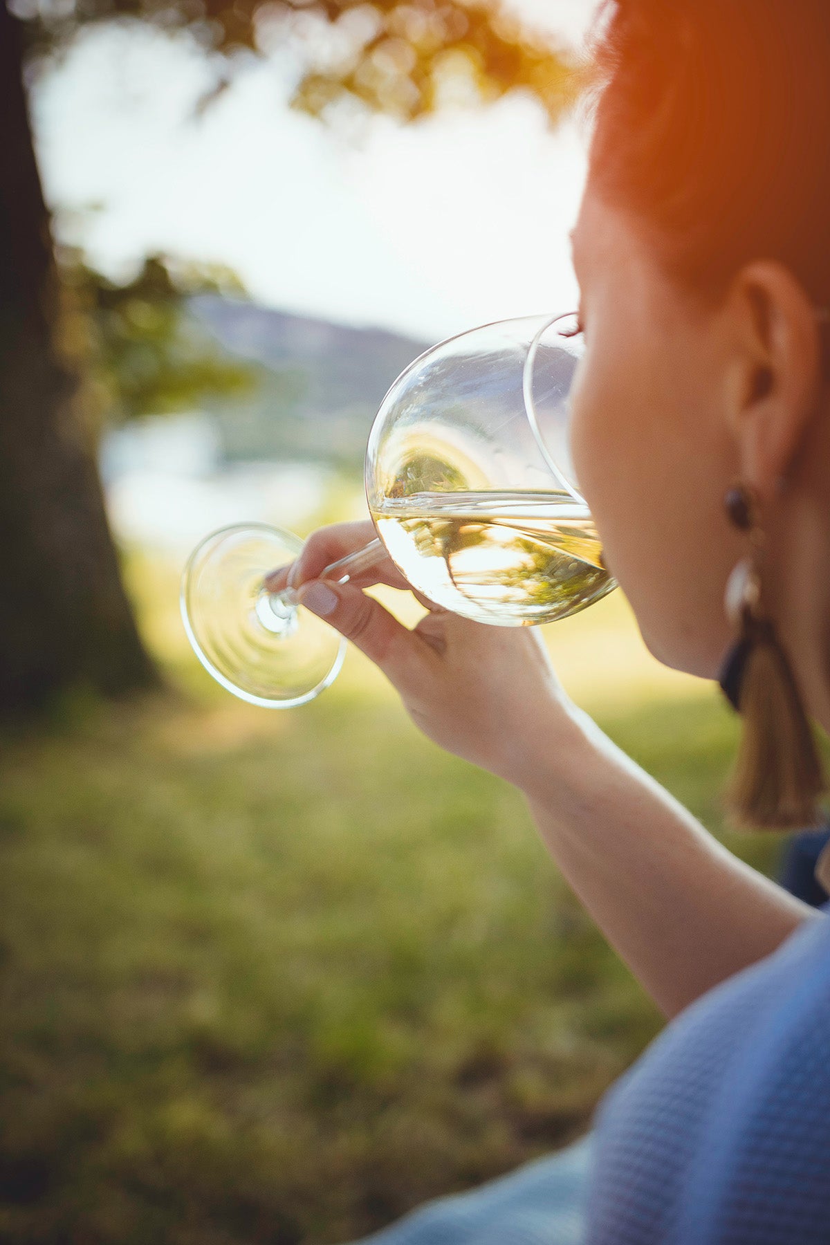 Eine Frau trinkt lieblichen Wein in der Sonne.